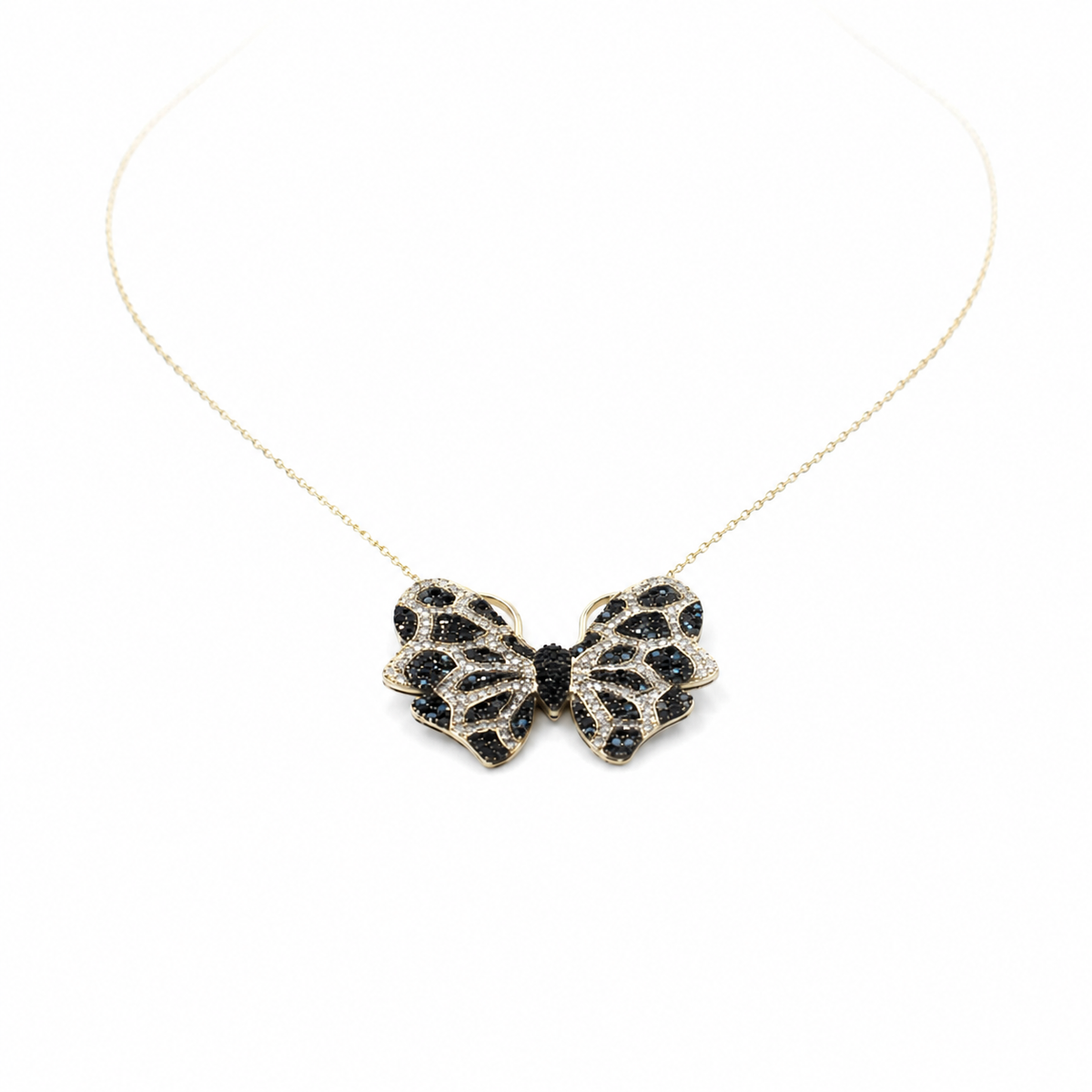 Gold-tone butterfly necklace with black and turquoise-inspired detailing on a fine chain.