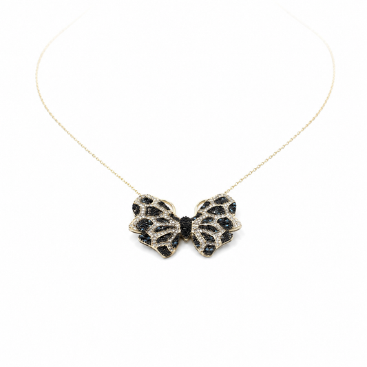 Gold-tone butterfly necklace with black and turquoise-inspired detailing on a fine chain.