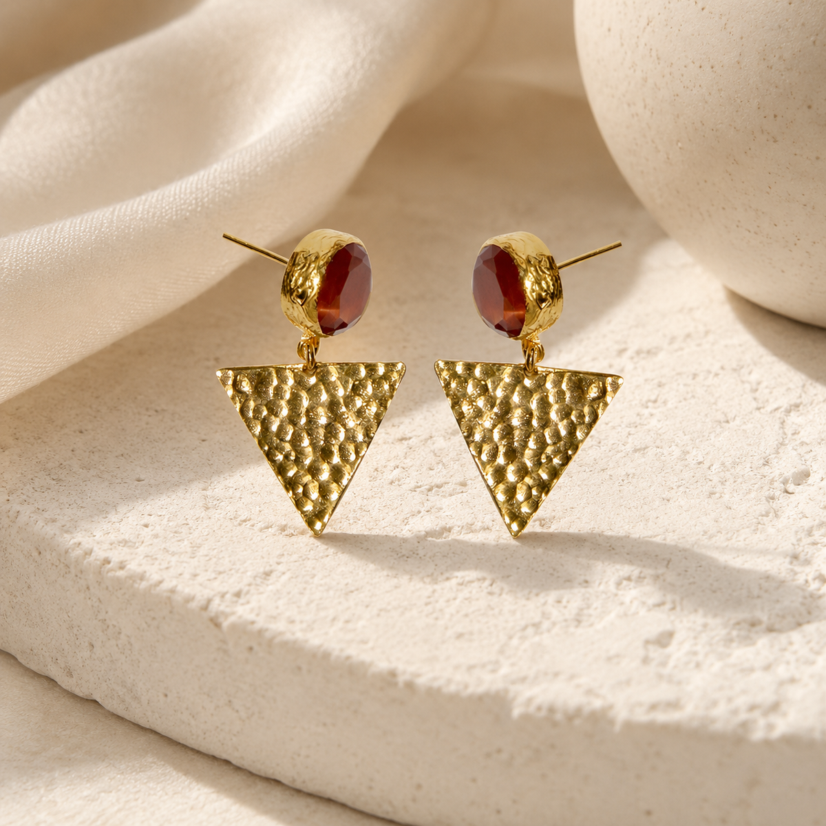 Gold-tone drop earrings with orange faceted accents and triangle pendants.