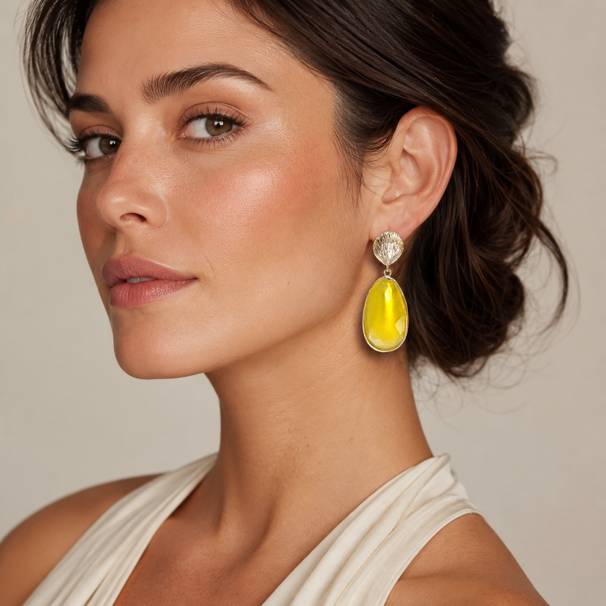 Pair of gold-tone statement drop earrings with textured shell tops and faceted yellow cat eye drops.