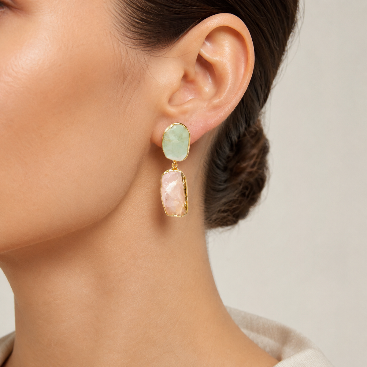 Gold-plated drop earrings with soft green and blush stones.