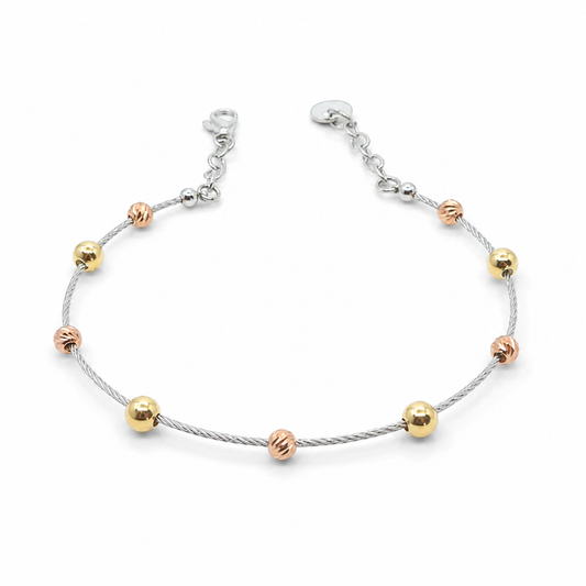 Silver bracelet with separated gold beads on a white background.