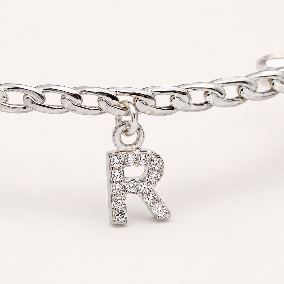 Close view of the CZ initial charm on the cuff bracelet.