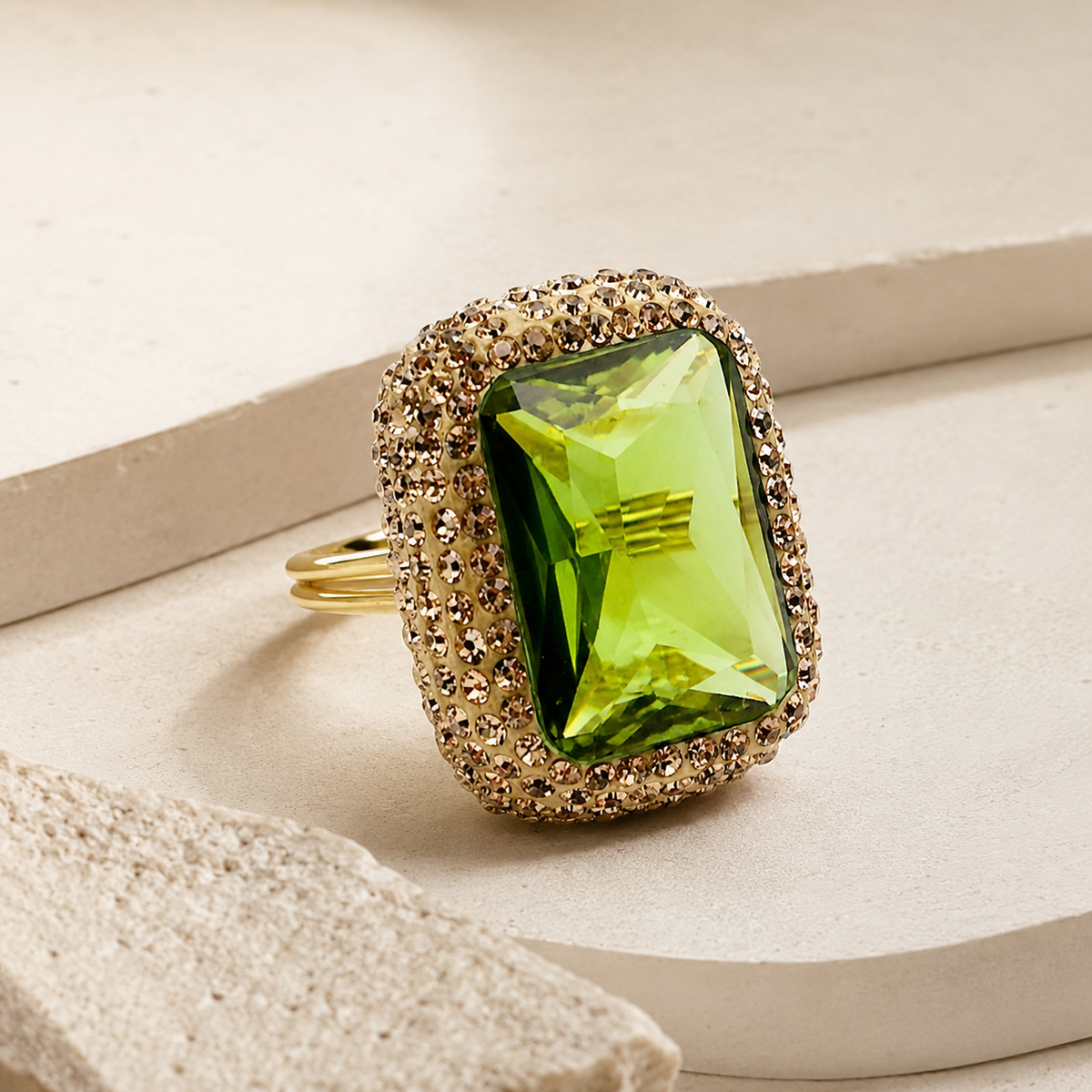 An angled view of the octagon ring with a green faceted stone and gold-tone band.