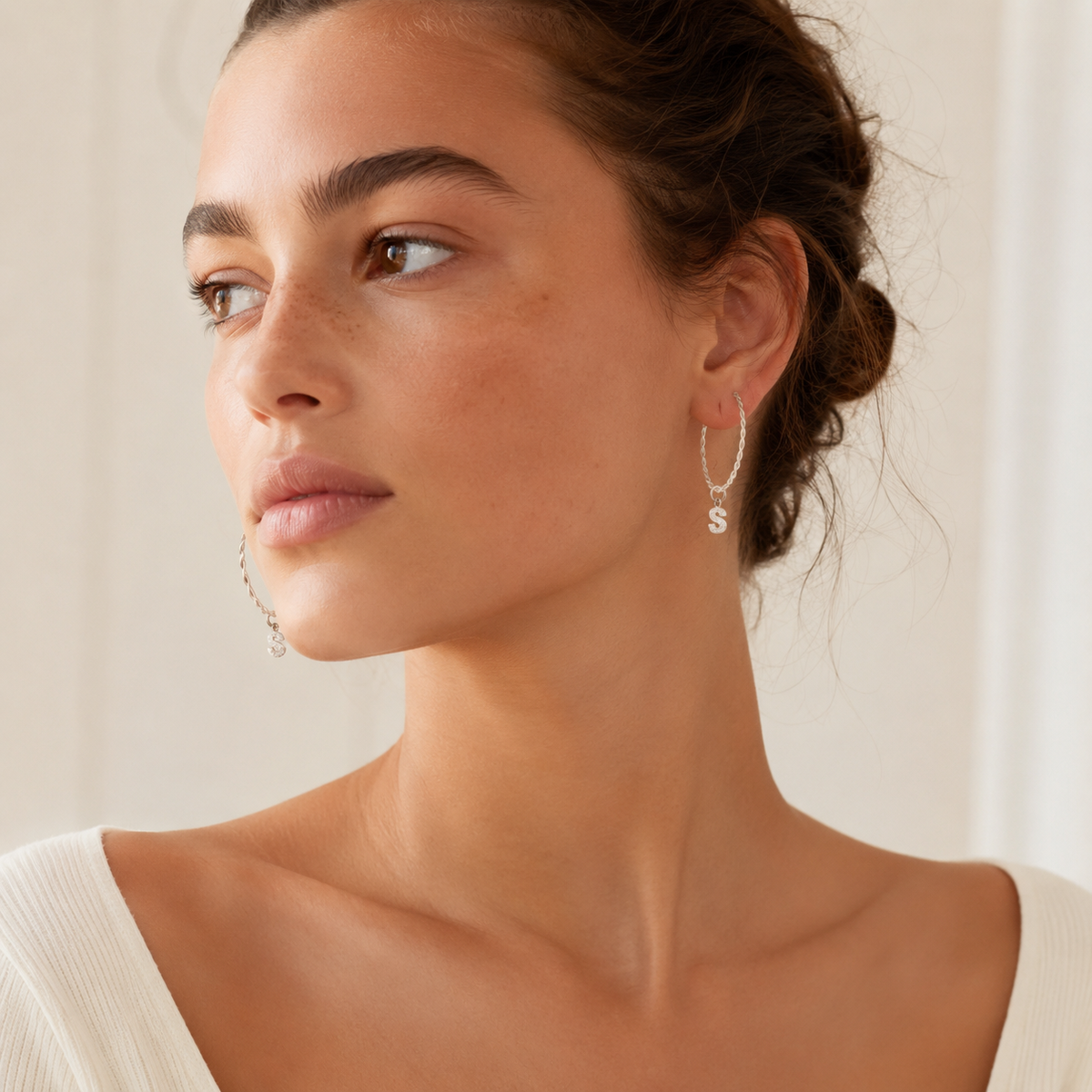 Twisted hoop earrings with a sparkling initial charm.