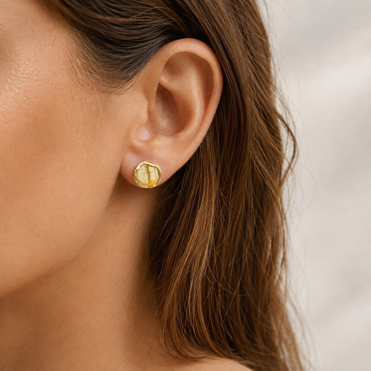 Pair of rough citrine stud earrings shown on a white background.