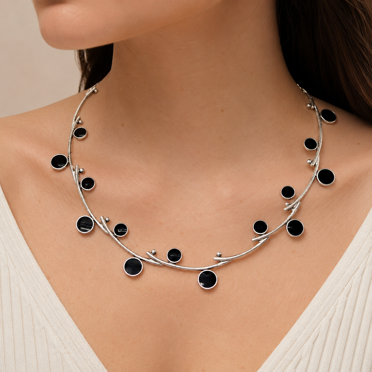 Silver-tone open wire collar necklace with black stone details shown on a white background.