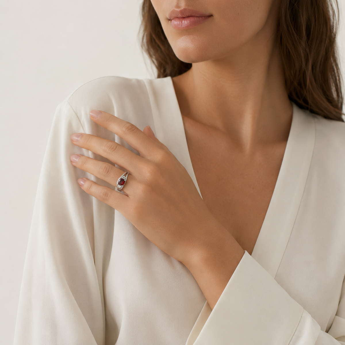 A silver-tone ring featuring a deep red ruby stone.