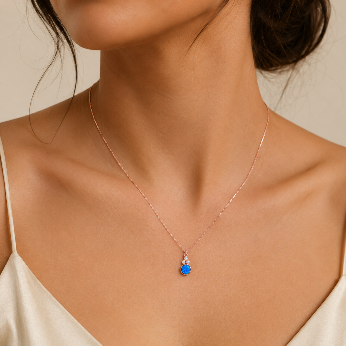 Blue opal pendant necklace with delicate sparkling accents and a rose gold-tone chain.