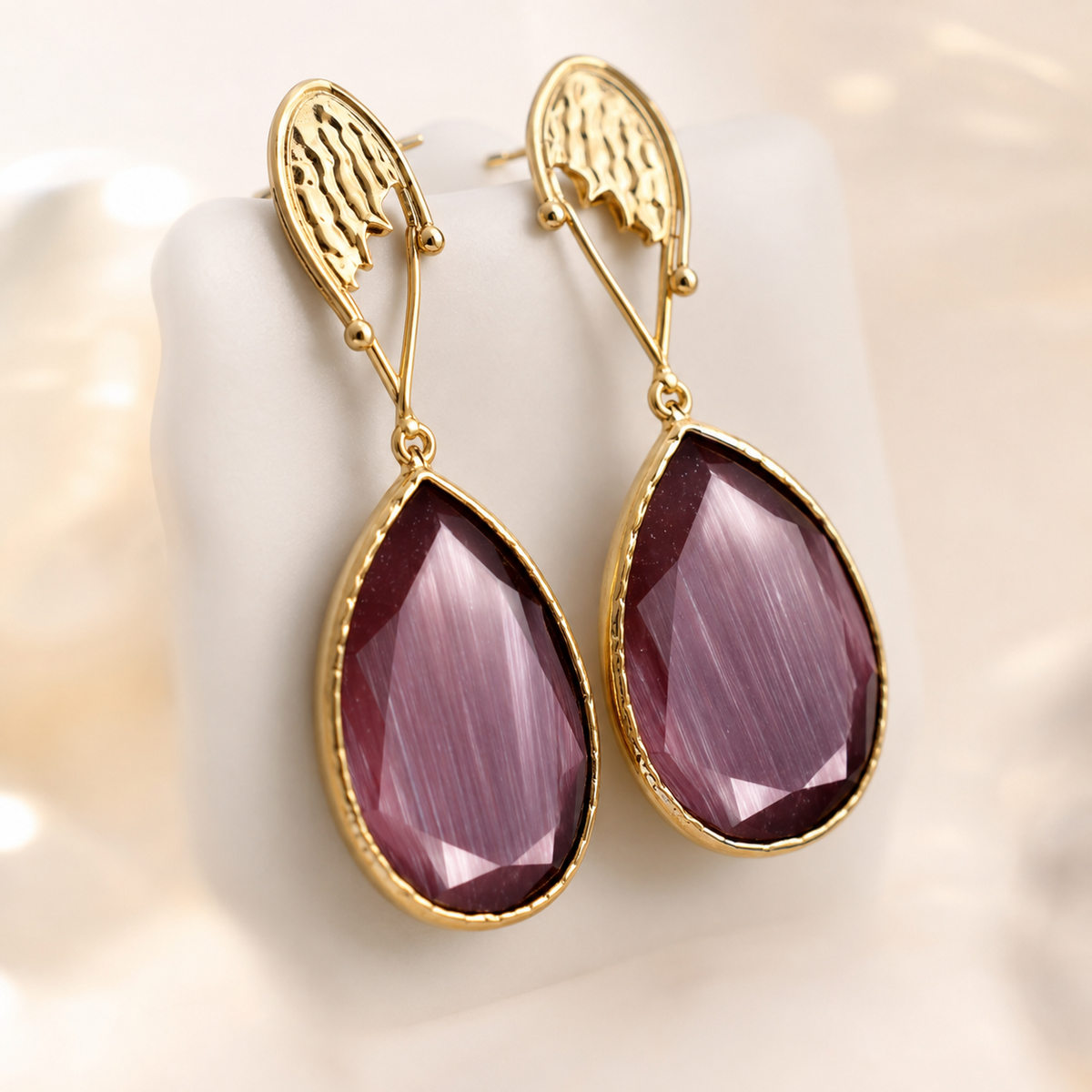 Gold-plated purple drop earrings styled on a model.