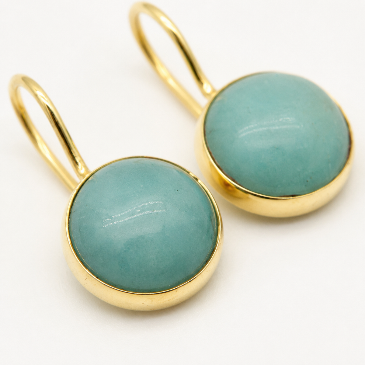 Close view of clear quartz drop earrings in a gold-plated setting.