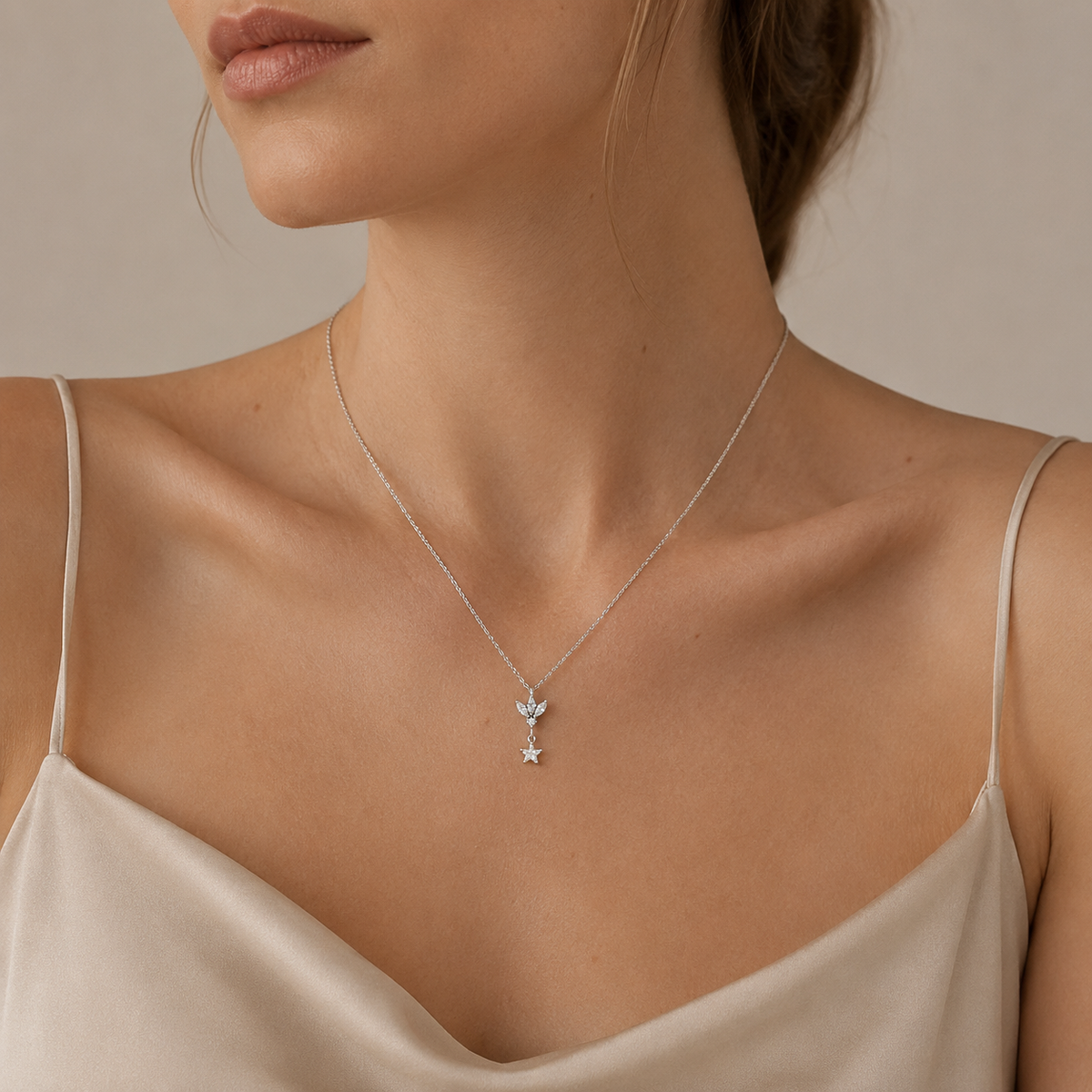 A silver-tone pendant necklace with a lotus-inspired charm and clear star drop.