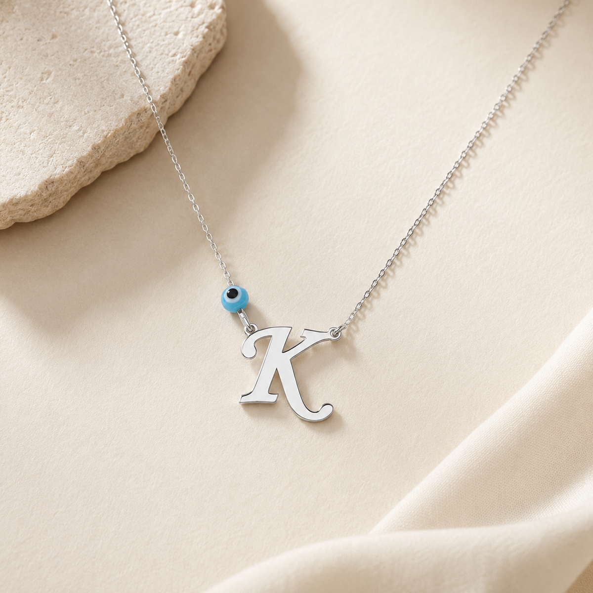 Personalized initial necklace with a silver-tone finish and blue evil eye charm.