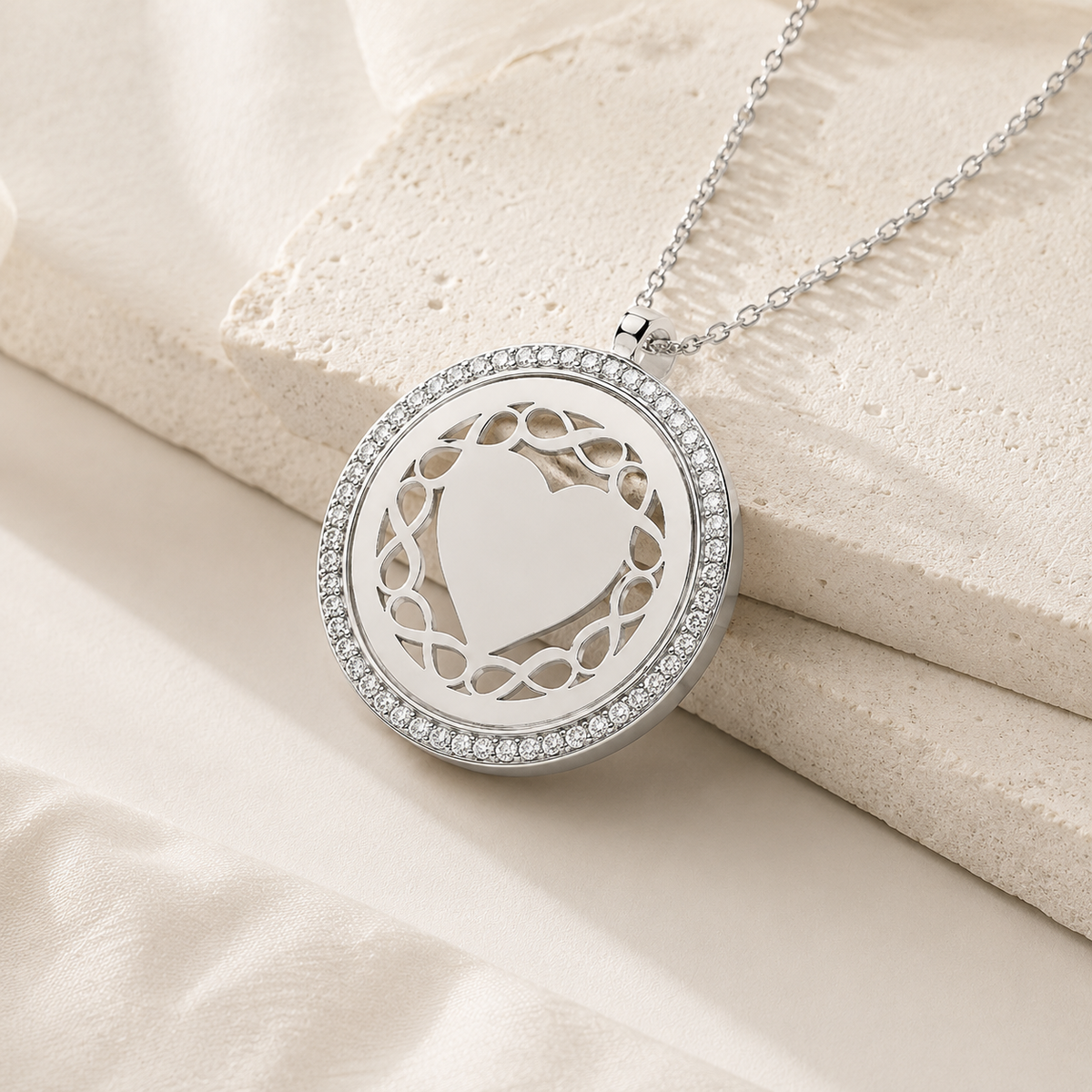 Angle view of a round silver-tone pendant necklace with a decorative frame.