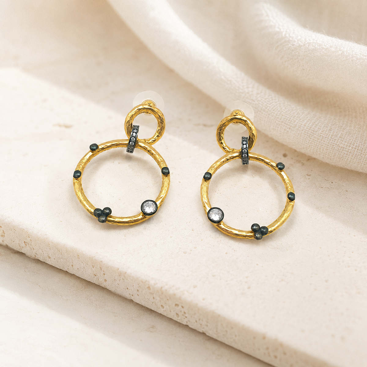 Pair of gold-plated double circle earrings on a white background.