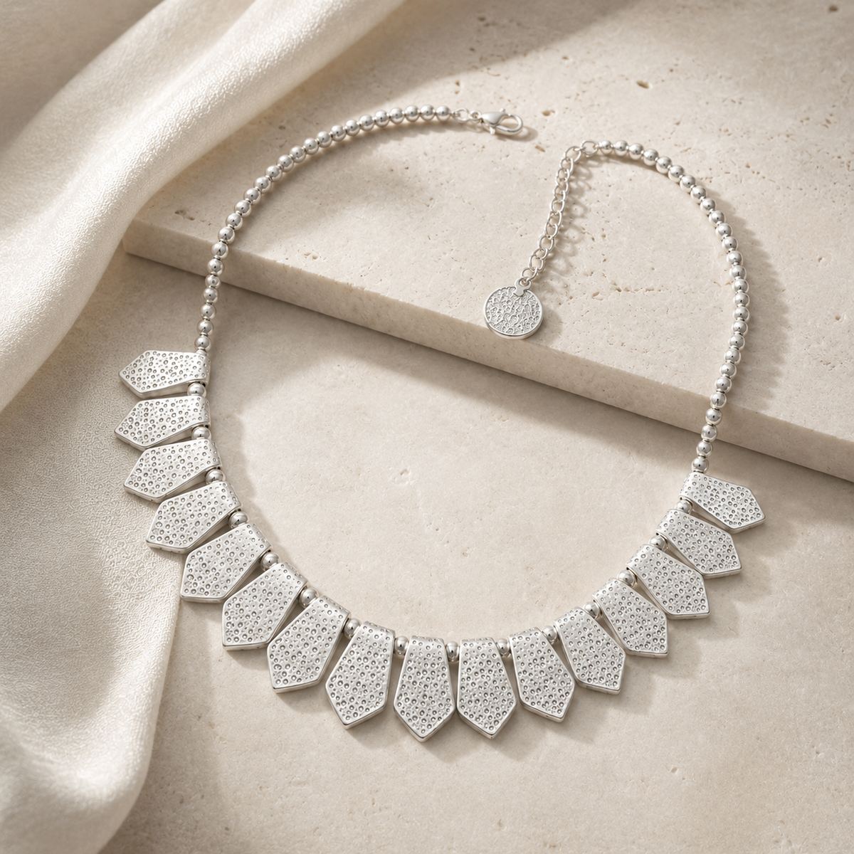 Silver-tone statement necklace with a layered bib silhouette.