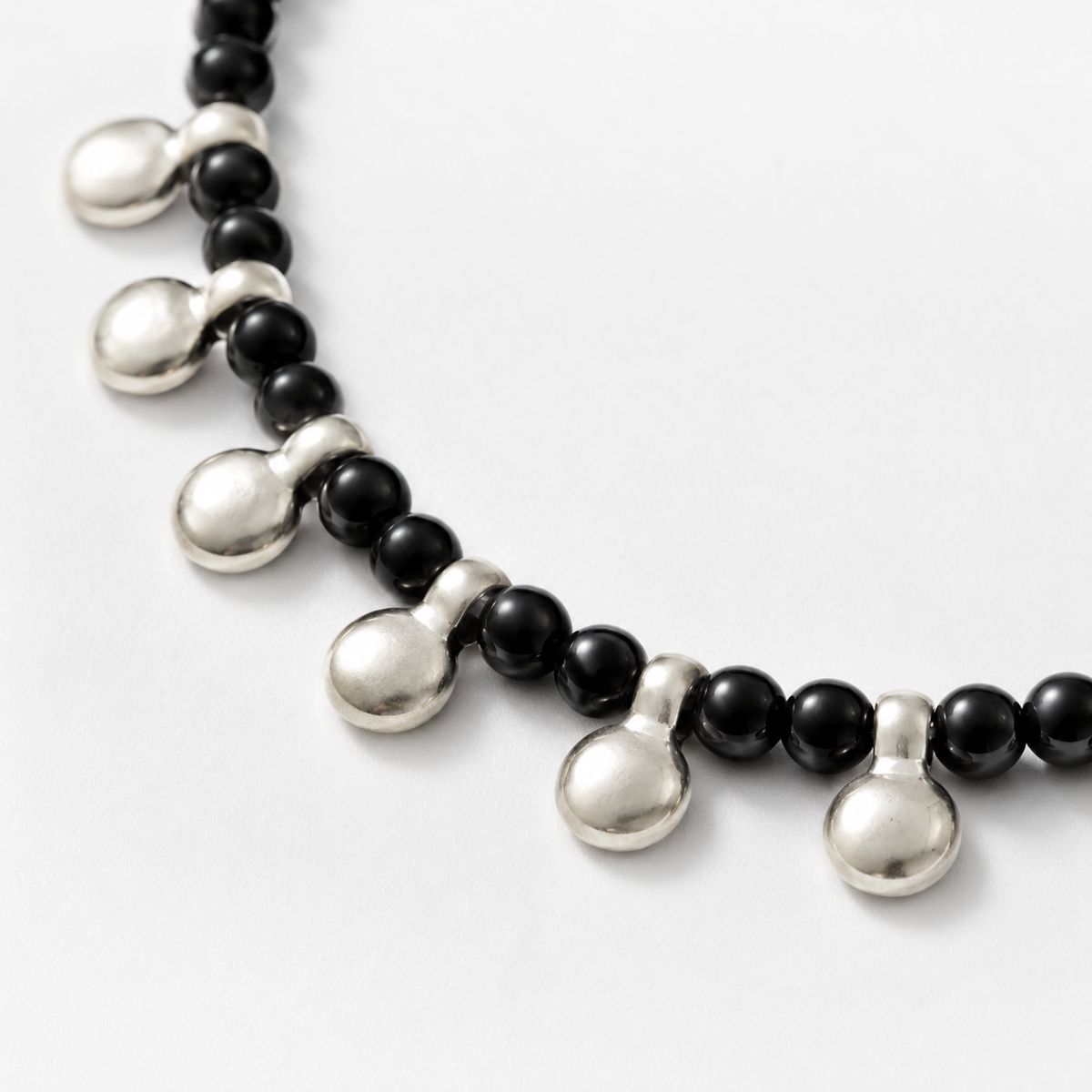 Close view of the black beads and silver disc details.