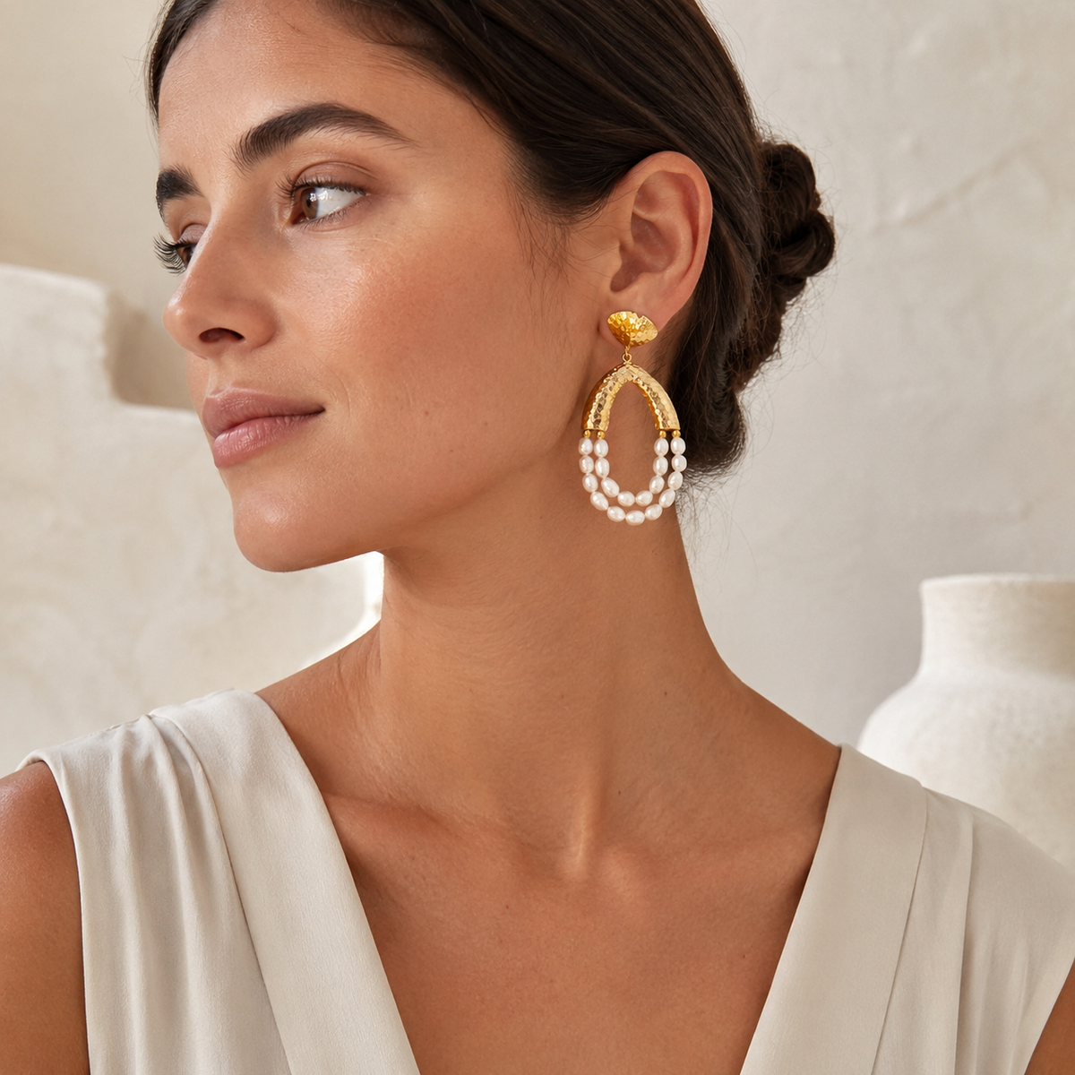 Pair of statement earrings with hammered gold-tone tops and pearl fringe drops.