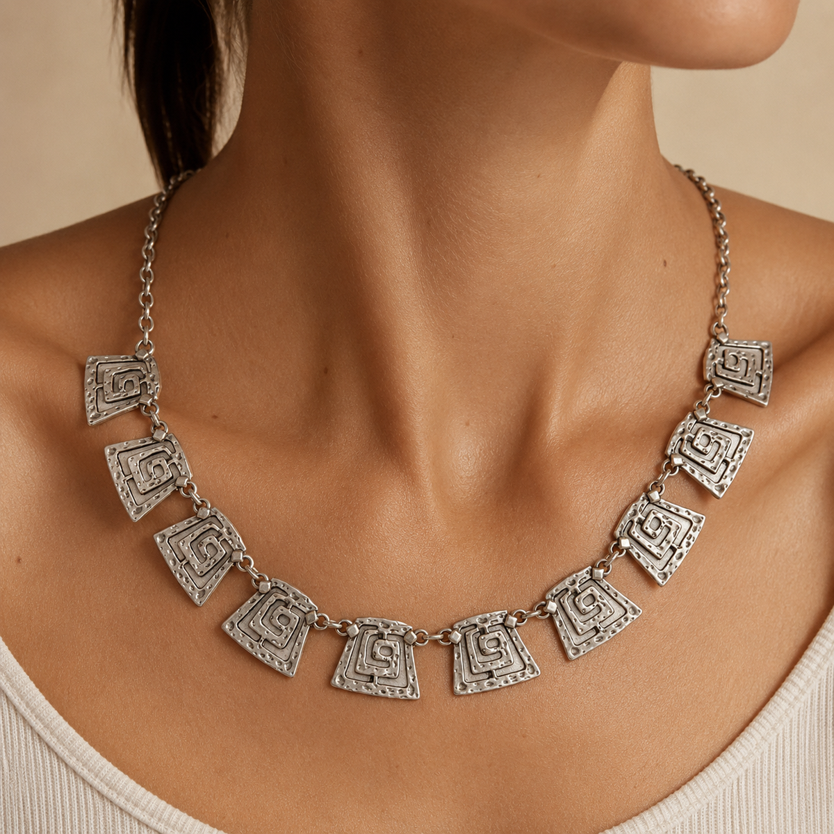 Silver-tone spiral square link necklace shown from above on a white background.