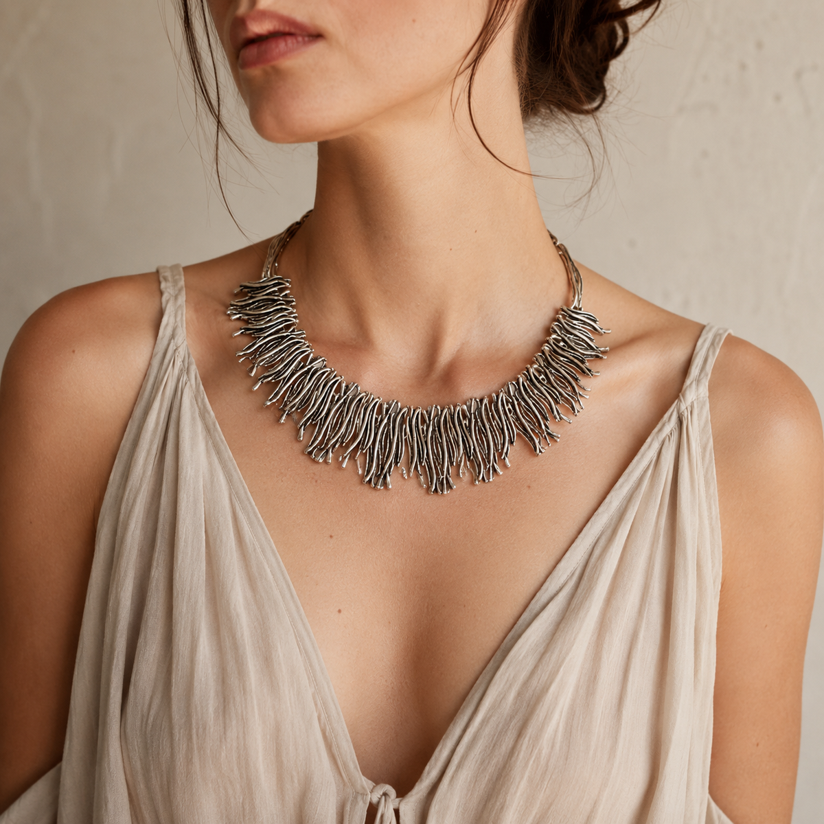 Silver-tone organic fringe necklace styled as a bold collar piece.