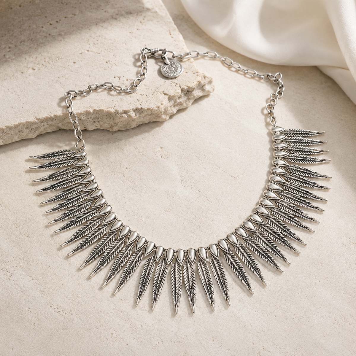 Silver-tone statement collar necklace with a sculptural shape.