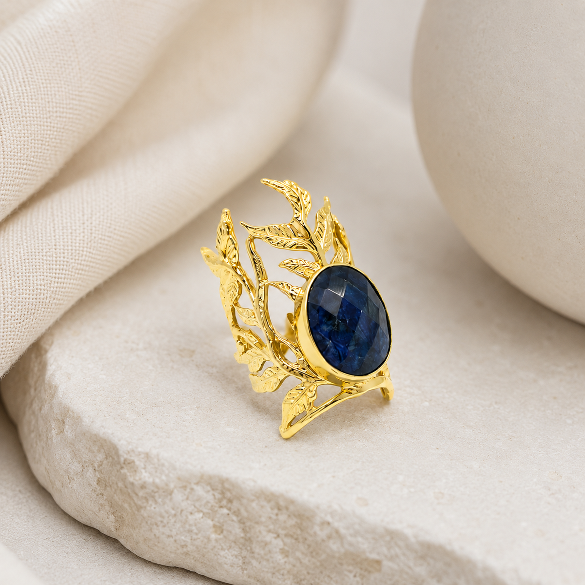 Navy blue oval statement ring with a gold-plated leaf filigree setting.