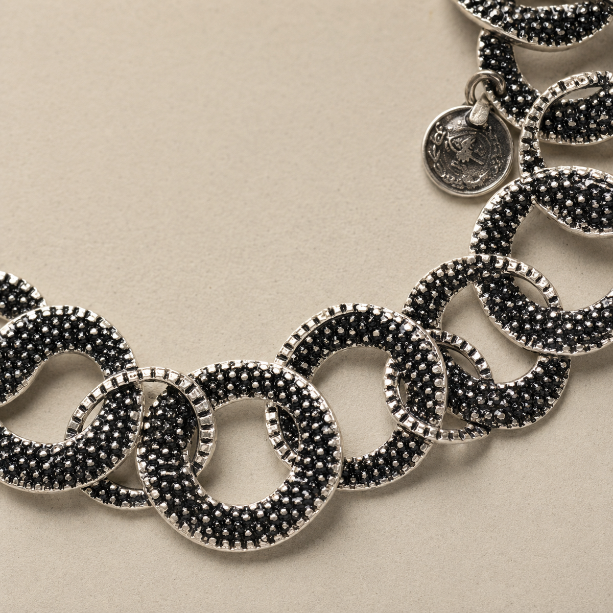 Close view of the necklace's textured oval links and silver-tone finish.
