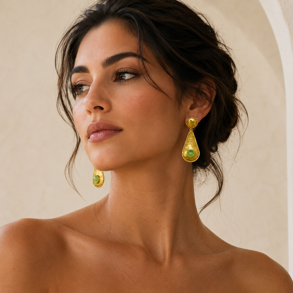 Gold-plated drop earrings with a hammered surface and green stone.