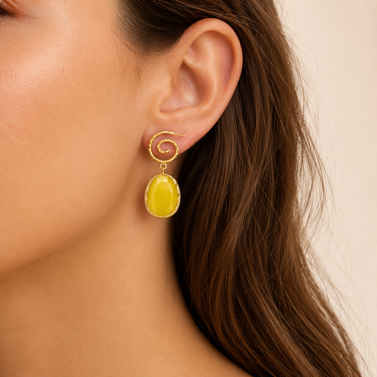 Pair of yellow spiral earrings with gold-plated detailing and oval drops.