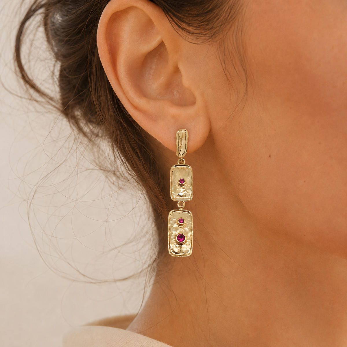 Gold-plated triple rectangle earrings with a polished textured surface and pink stones.