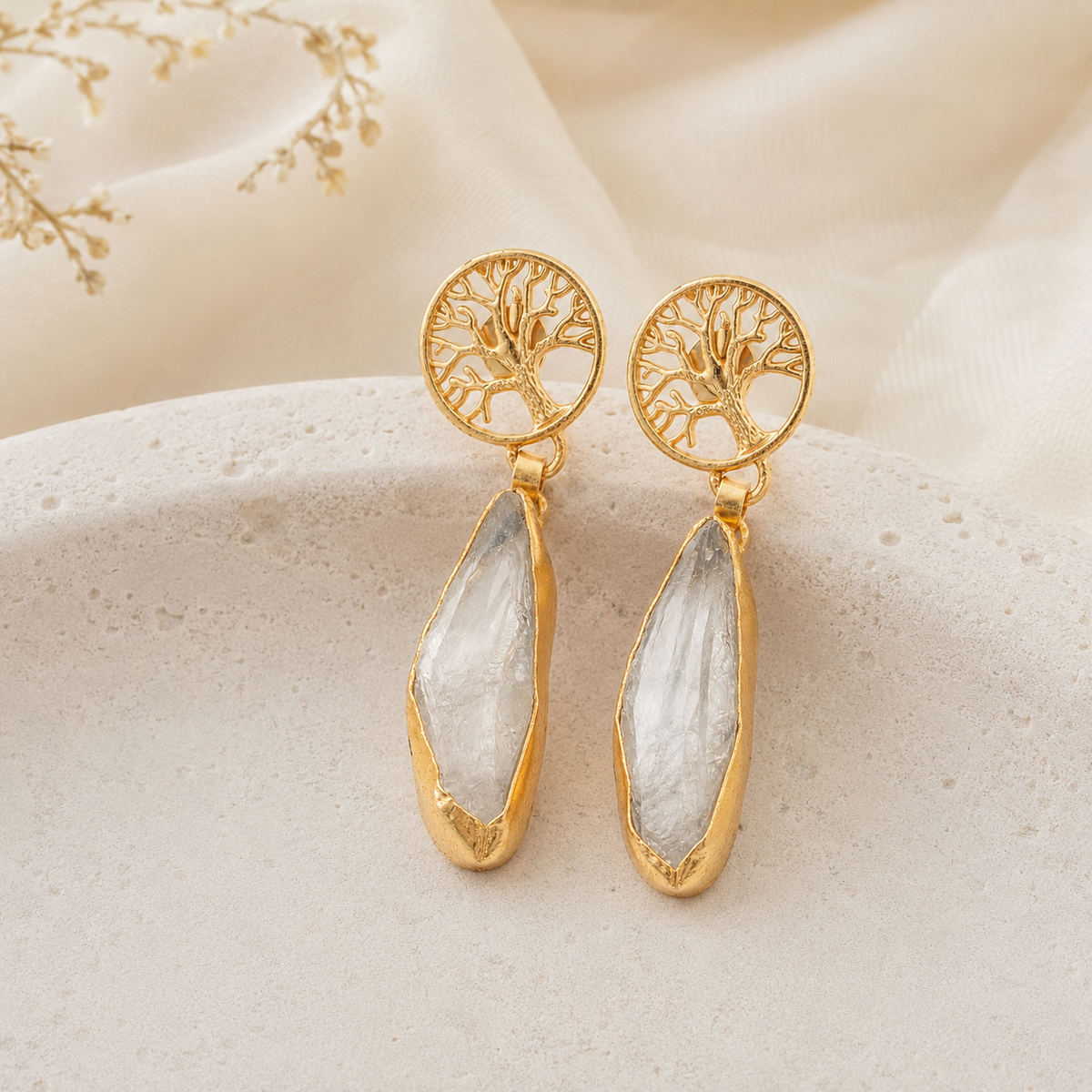 Gold-tone drop earrings with a clear faceted stone accent.