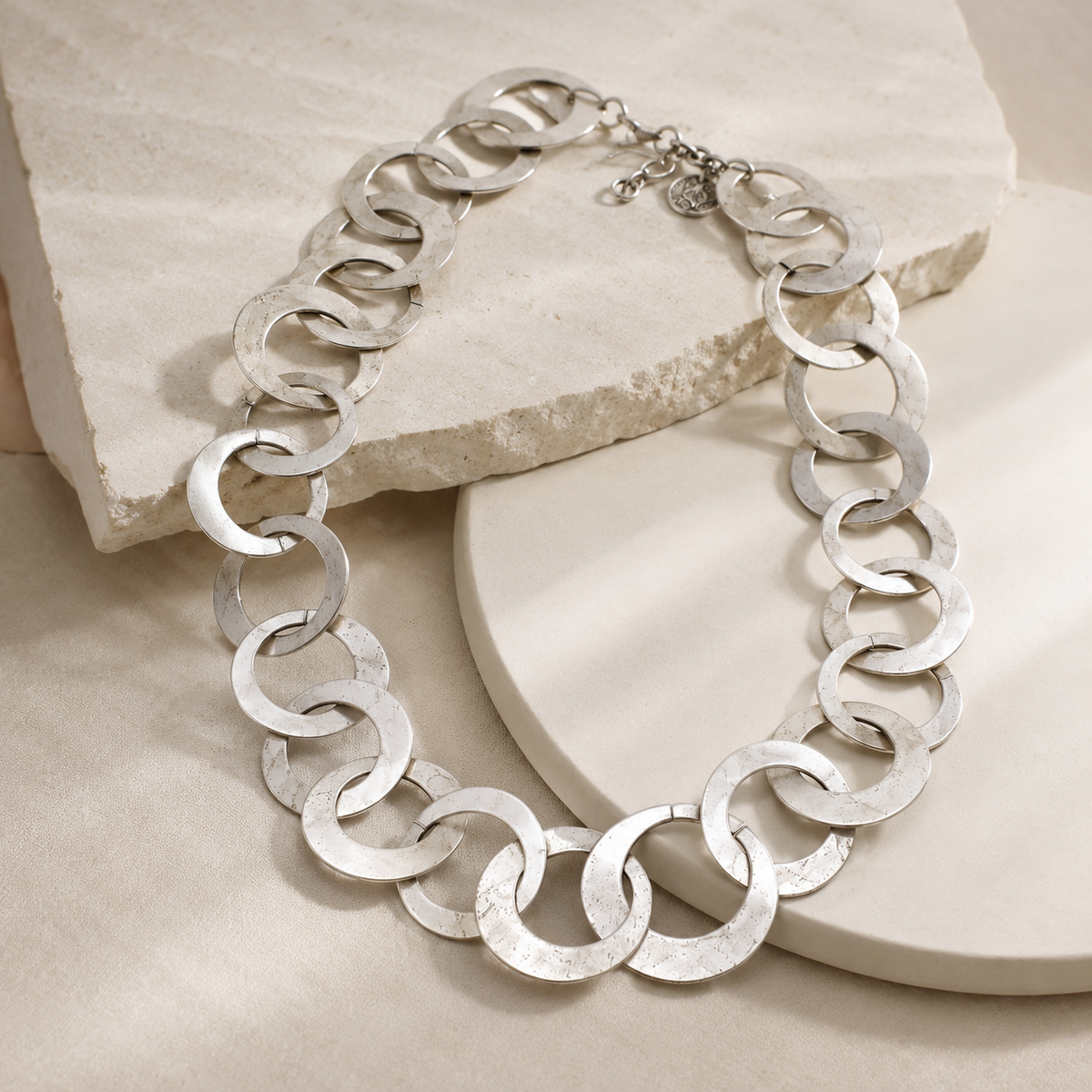 Angled view of a smooth silver-tone circle link necklace.