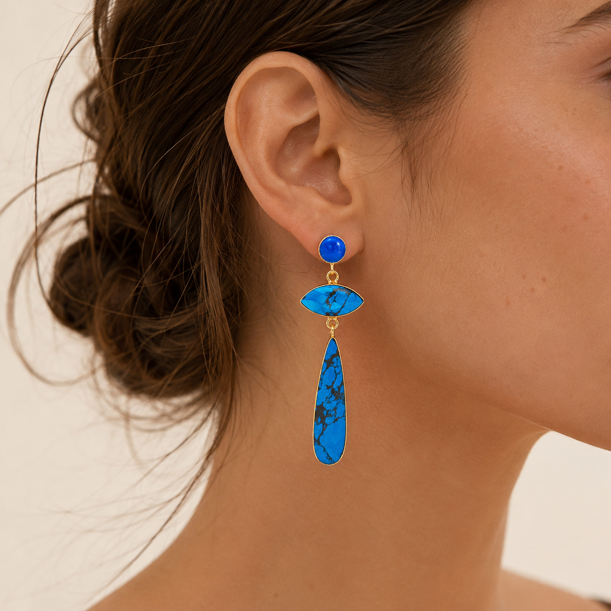 Front view of long turquoise and gold-plated drop earrings on a white background.