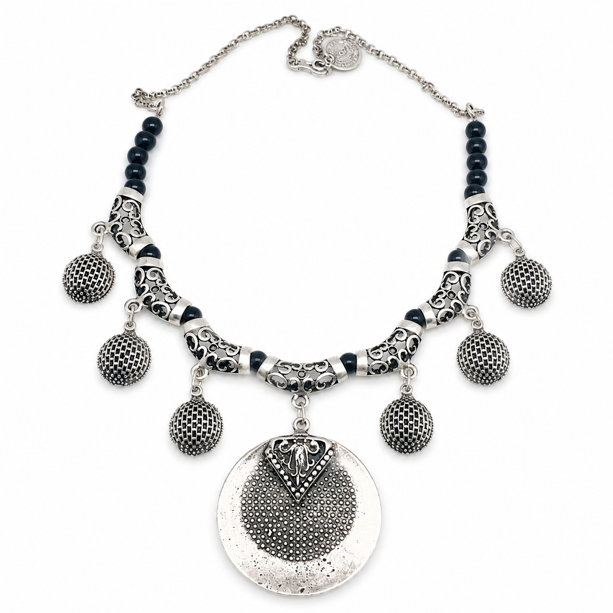 Black bead necklace with a silver-toned medallion pendant and textured charms.