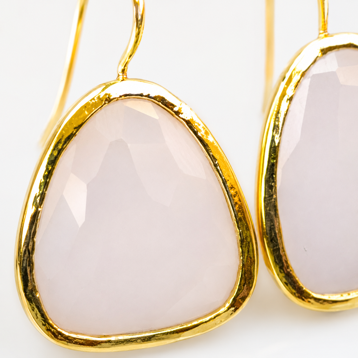 Close view of the white chalcedony stone and gold-plated setting.