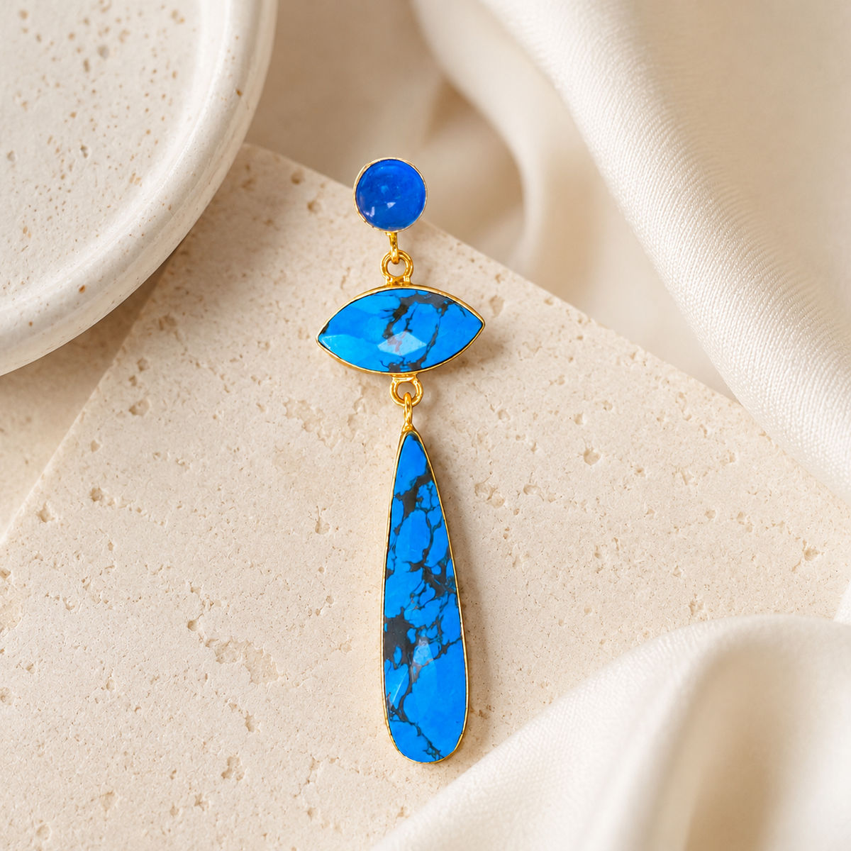 Pair of long drop earrings with turquoise stones and gold-tone accents.
