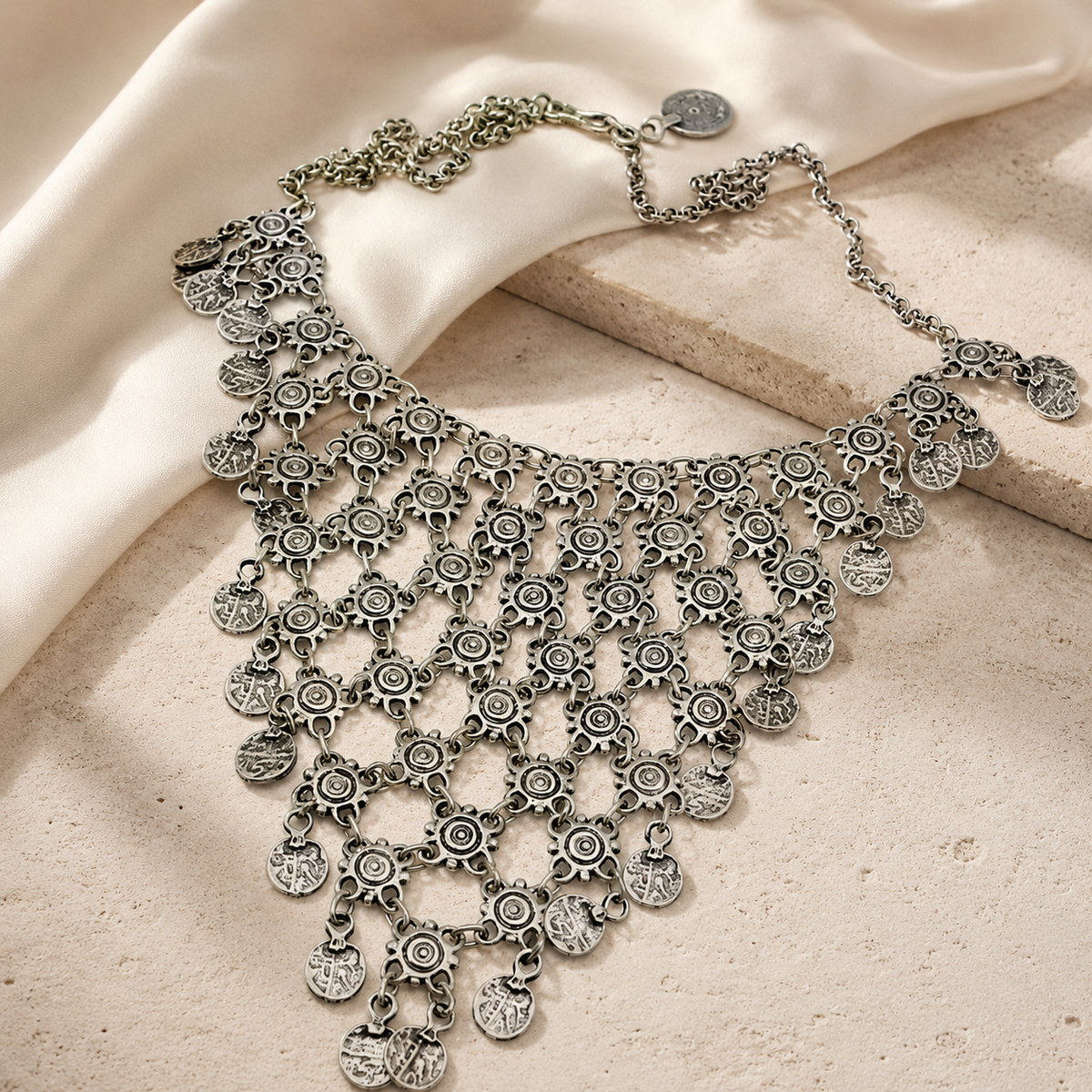 Statement necklace with cascading silver-tone coin charms and a detailed openwork look.