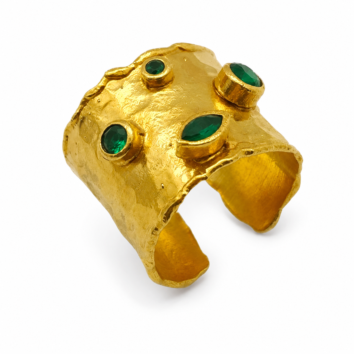 Gold-plated adjustable cuff ring with emerald green stones and a textured sculptural surface.