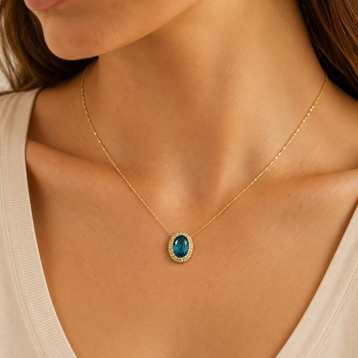 Gold-tone necklace with a green oval pendant shown against a white background.