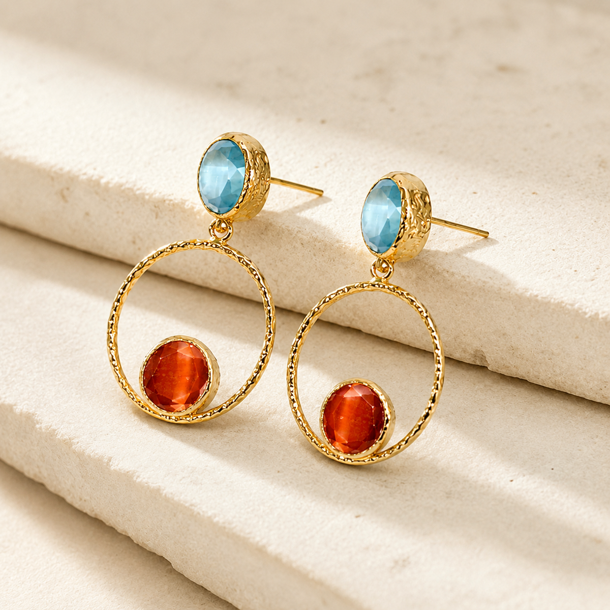 Side view of gold-plated drop earrings with a textured hoop and colorful accents.