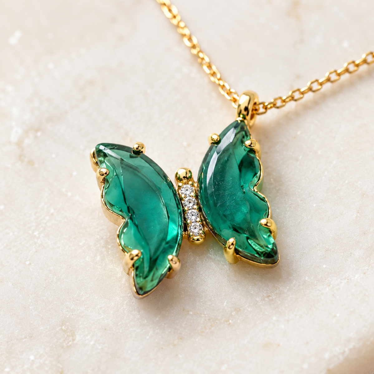 Close view of the green butterfly pendant and gold-tone setting.