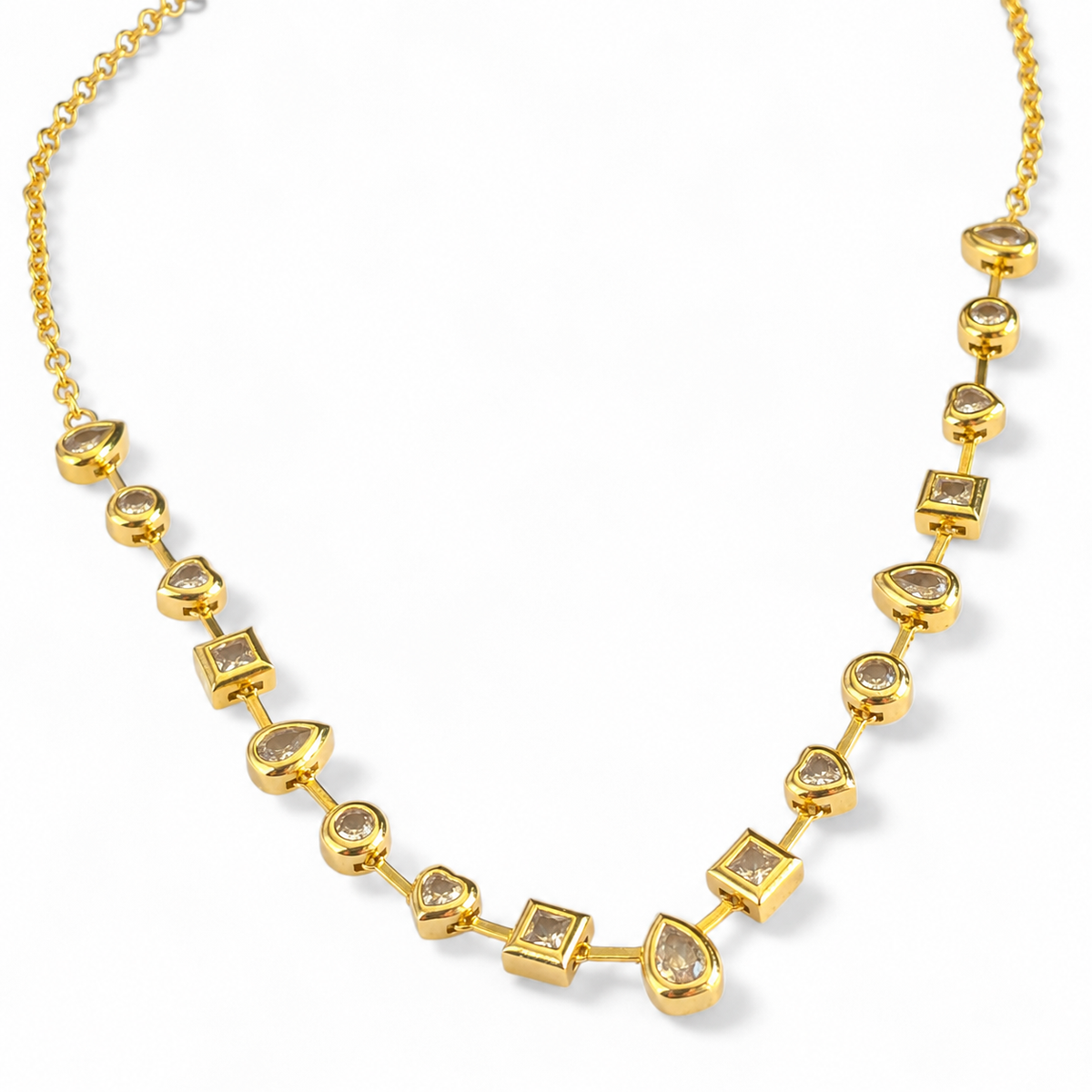Angled view of a gold-tone station necklace with mixed shape clear stones.