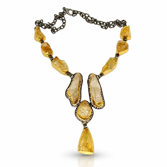 Citrine raw crystal Y necklace with golden stone accents and a dark chain.