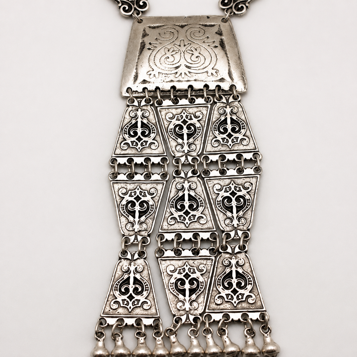 Close view of the necklace’s detailed triangle links and pendant.