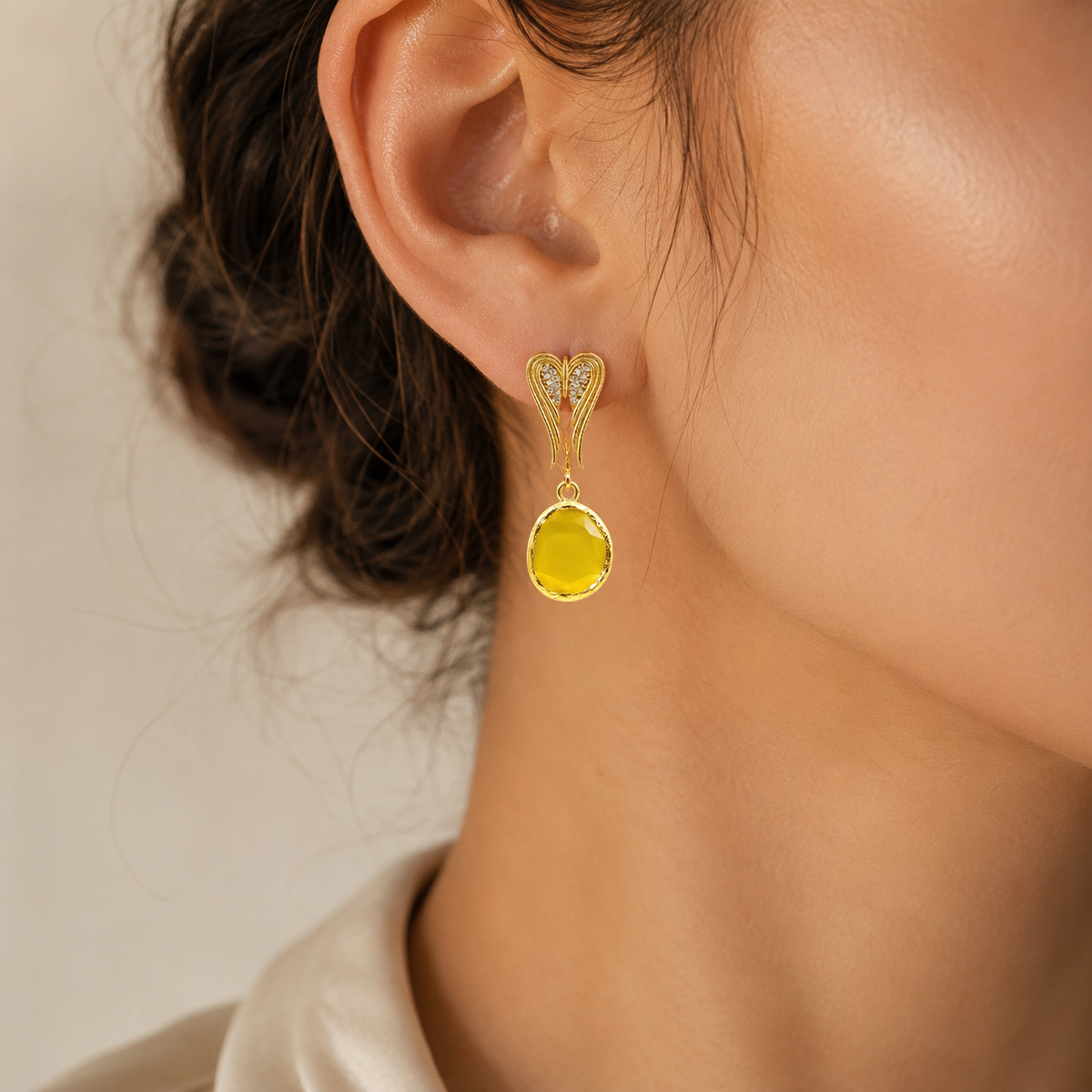 Gold-tone heart-shaped dangle earrings shown from the front.