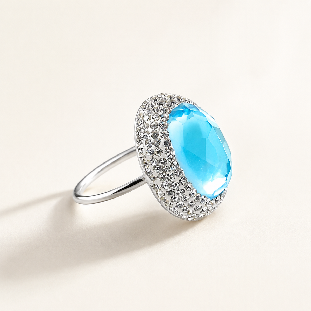 Side angle of a silver-tone ring with a large baby blue stone.