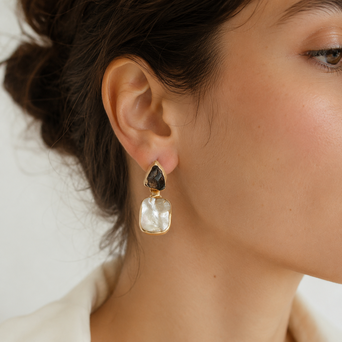 Pair of gold-plated drop earrings with smoky quartz and mother of pearl shown against a white background.