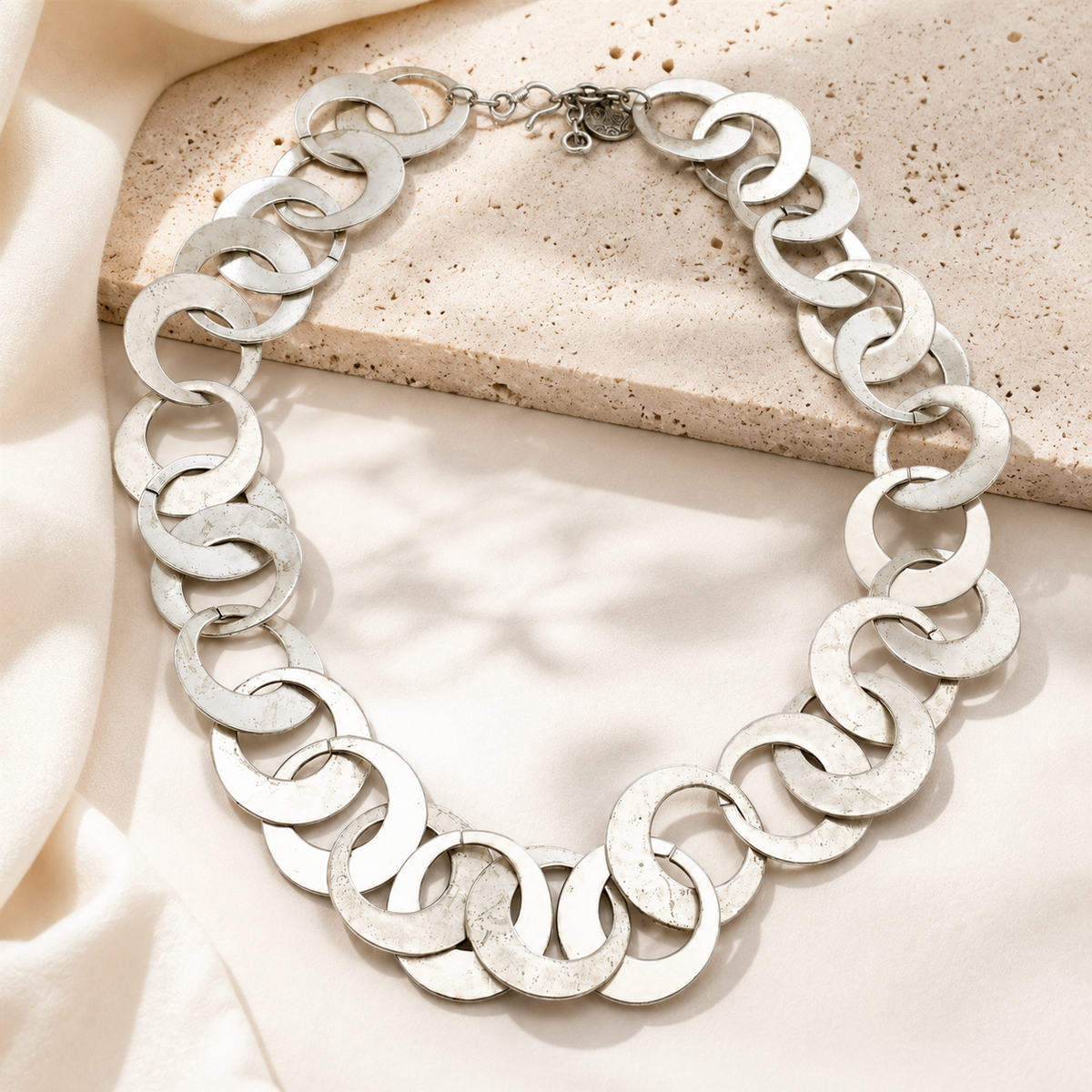Silver-tone linked circle necklace with a sculptural, modern silhouette.