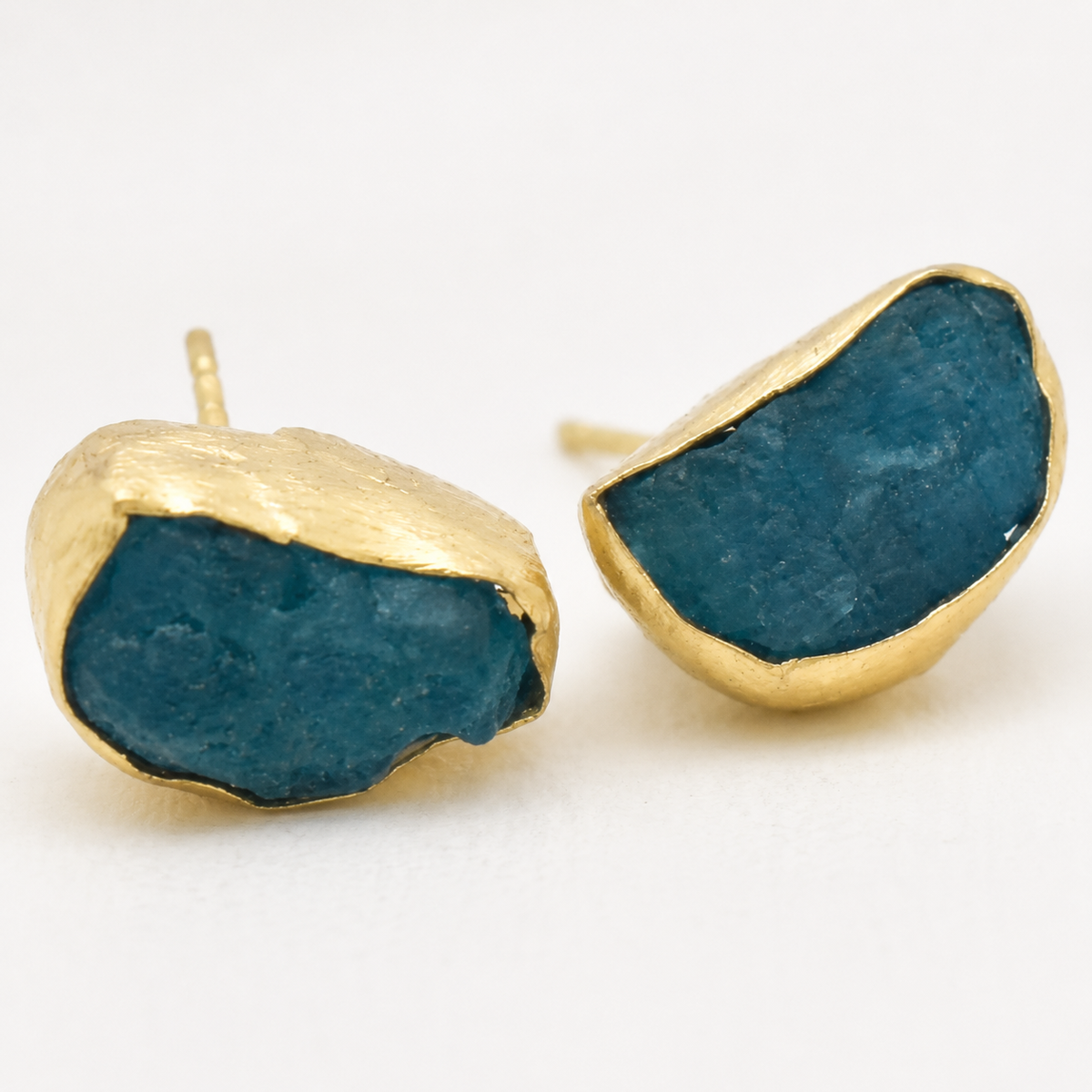 Detail view of raw apatite stud earrings with textured blue stones.
