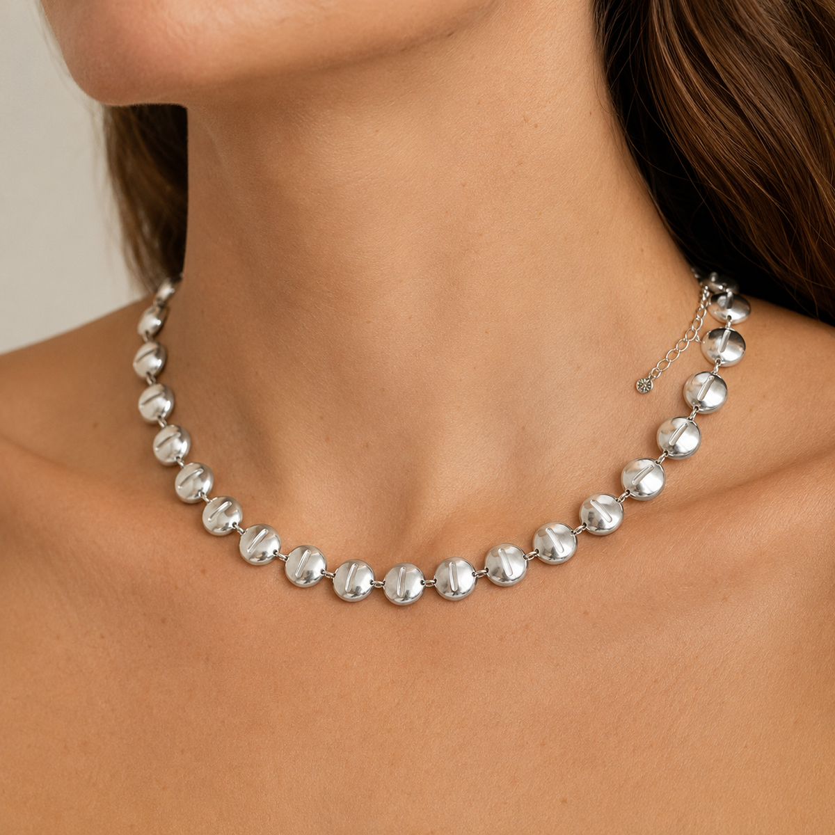 Silver-tone round disc collar necklace shown from above on a white background.